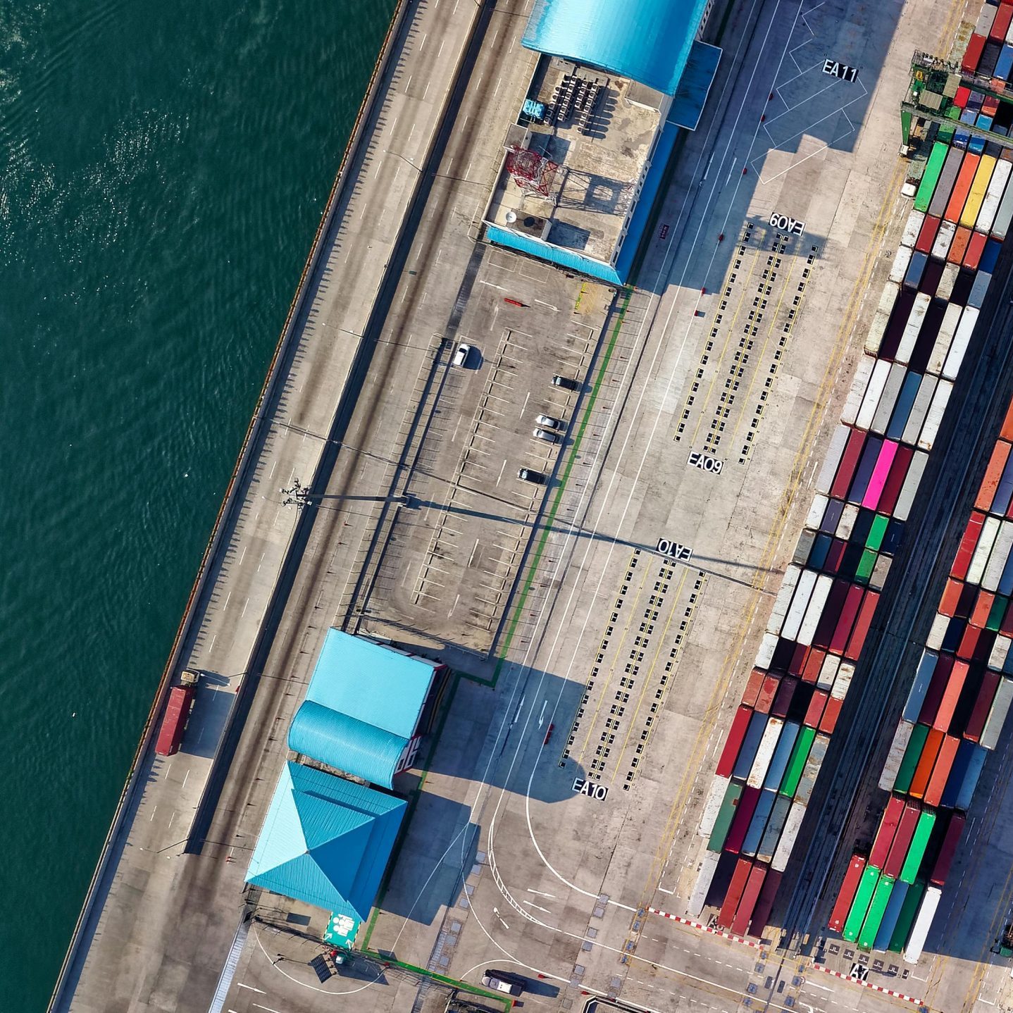Top view of colorful shipping containers at a bustling port in Jakarta, Indonesia.